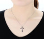 black spinel and cubic zirconia cross in black and white rhodium over sterling silver shown being worn