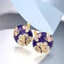cz butterfly and flower earrings in blue enamel and 18k yellow gold over sterling silver shown in a lifestyle photo