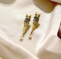 brown and white cubic zirconia owl earrings in 18k yellow gold over sterling silver shown in a lifestyle photo