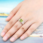 peridot and white zircon bridge ring in rhodium over sterling silver worn on a hand