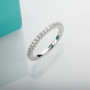 moissanite round half band eternity ring in rhodium over sterling silver shown in a lifestyle photo