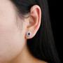 sapphire and white zircon halo stud earrings in rhodium over sterling silver worn on the ear