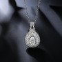 pear moissanite baguette and round halo pendant necklace in rhodium over sterling silver shown in a lifestyle photo