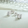 7mm round moissanite stud earrings in rhodium over sterling silver shown in a lifestyle photo