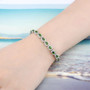 chrome diopside and white zircon halo bracelet in rhodium over sterling silver worn on a wrist
