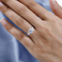 moissanite round trilogy ring in rhodium over sterling silver worn on a hand