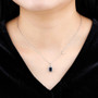 sapphire emerald cut and white zircon halo necklace in rhodium over sterling silver worn around the neck