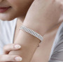 moissanite triple row tennis bracelet in 18k rose gold over sterling silver worn on a wrist
