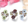 close up of garnet and multi gemstone flower cluster bypass ring in rhodium over sterling silver