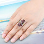 garnet and multi gemstone flower cluster bypass ring in rhodium over sterling silver worn on a hand