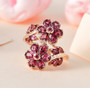 rhodolite garnet floral bypass ring in 18k rose gold over sterling silver shown in a lifestyle photo