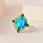 quartz triplet chrome diopside and blue apatite halo ring in rhodium over sterling silver shown in a lifestyle photo