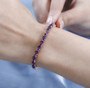 amethyst and rhodolite garnet tennis bracelet in 18k rose gold over sterling silver worn on a wrist