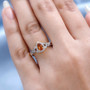 spessartine garnet and white zircon halo ring in 18k yellow gold over sterling silver worn on a hand