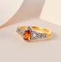 spessartine garnet and white zircon halo ring in 18k yellow gold over sterling silver shown in a lifestyle photo