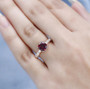 rhodolite garnet and moissanite ring in 18k rose gold over sterling silver worn on a hand