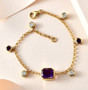 amethyst and moissanite bezel charm bracelet in 18k yellow gold over sterling silver shown in a lifestyle photo