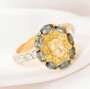 yellow diamond white diamond and alexandrite halo ring in 18k yellow gold shown in a lifestyle photo