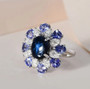 star sapphire tanzanite and moissanite halo ring in rhodium over sterling silver shown in a lifestyle photo