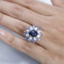 star sapphire tanzanite and moissanite halo ring in rhodium over sterling silver worn on a hand