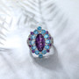 amethyst blue topaz and zircon halo cluster ring in rhodium over sterling silver shown in a lifestyle photo