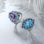 close up of amethyst blue topaz and zircon halo cluster ring in rhodium over sterling silver