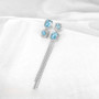 sky blue topaz and zircon mismatched dangle earrings in rhodium over sterling silver shown in a lifestyle photo