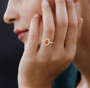 spessartine garnet and diamond halo wedding ring in 14k yellow gold worn on a hand
