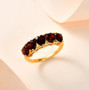 garnet heart five stone band ring in 18k yellow gold over sterling silver shown in a lifestyle photo