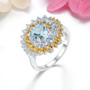 sky blue topaz and citrine halo ring in rhodium over sterling silver shown in a lifestyle photo