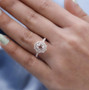 morganite and moissanite halo wedding ring in 18k rose gold over sterling silver worn on a hand