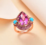 pink quartz sleeping beauty turquoise and rhodolite garnet ring in 18k rose gold over sterling silver shown in a lifestyle photo