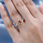 spessartine garnet and moissanite halo infinity shank ring in 18k yellow gold over sterling silver worn on a hand