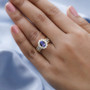 tanzanite and moissanite wedding ring in 18k yellow gold over sterling silver worn on a hand