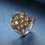 close up of citrine and black spinel cluster ring in black and white rhodium over sterling silver