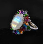 oval rainbow moonstone and multi gemstone halo ring in rhodium over sterling silver shown in a lifestyle photo
