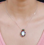 oval rainbow moonstone and multi gemstone halo pendant necklace in rhodium over sterling silver worn around the neck