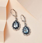 aquamarine sapphire and zircon dangle earrings in rhodium over sterling silver shown in a lifestyle photo