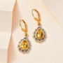 heliodor yellow sapphire and zircon dangle earrings in 18k yellow gold over sterling silver shown in a lifestyle photo