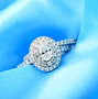 oval diamond halo two ring bridal set in 14k white gold shown in a lifestyle photo