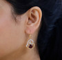 garnet and moissanite heart dangle earrings in 18k yellow gold over sterling silver worn on the ear