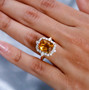 citrine and cushion moissanite halo ring in 18k yellow gold over sterling silver worn on a hand
