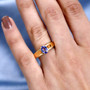tanzanite and white zircon solitaire ring in 18k yellow gold over sterling silver worn on a hand