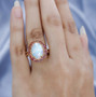 ethiopian opal and pink tourmaline halo ring in 18k yellow gold over sterling silver worn on a hand
