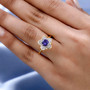 tanzanite and white zircon flower ring in 18k yellow gold over sterling silver worn on a hand