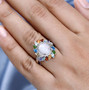 ethiopian opal multi gemstone and white zircon halo ring in rhodium over sterling silver worn on a hand