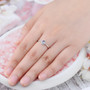tanzanite and white zircon halo ring in rhodium over sterling silver worn on a hand