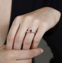 rubellite tourmaline tanzanite and white zircon three stone bypass ring in 18k rose gold over sterling silver worn on a hand