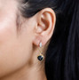 london blue topaz and moissanite heart dangle earrings in 18k yellow gold over sterling silver worn on the ear