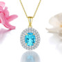swiss blue topaz and white zircon double halo pendant necklace in 18k yellow gold over sterling silver shown in a lifestyle photo
